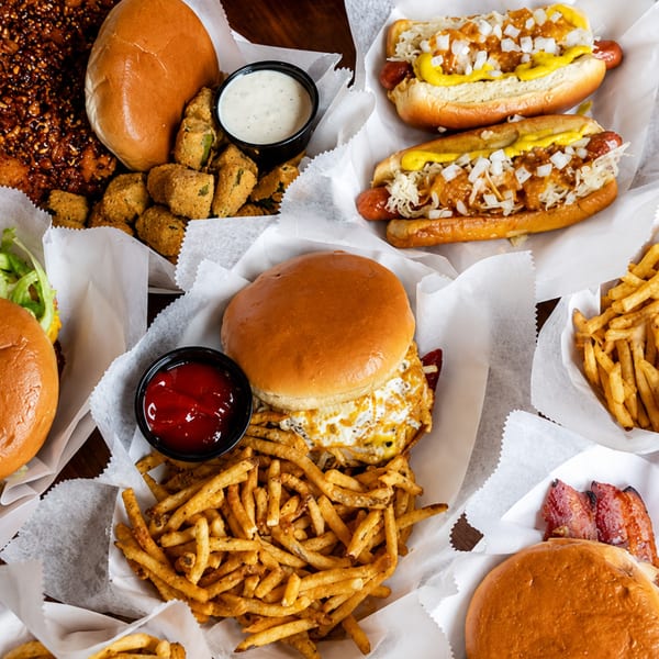 An overhead shot of various fast food items including burgers, hot dogs, fries, and fried okra.